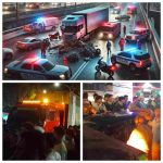 Ilustrasi kecelakaan lalu lintas malam hari di sebuah jembatan perkotaan. Sebuah truk besar menabrak beberapa mobil dan sepeda motor, dengan kendaraan yang rusak tersebar di jalan. Lampu darurat merah dan biru dari polisi dan ambulans menerangi lokasi, sementara petugas penyelamat menggunakan alat berat untuk evakuasi. Di latar belakang, terlihat lampu jalan dan siluet kota, dengan orang-orang berdiri di tepi jalan menyaksikan kejadian dengan ekspresi khawatir