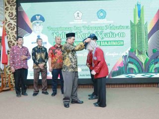 Pj. Bupati Barito Kuala, Dinansyah, S.Sos., M.M., secara simbolis menyematkan tanda peserta kepada mahasiswa KKN Universitas Muhammadiyah Banjarmasin (UMB) ke-10 tahun 2025 di Aula Selidah Marabahan.