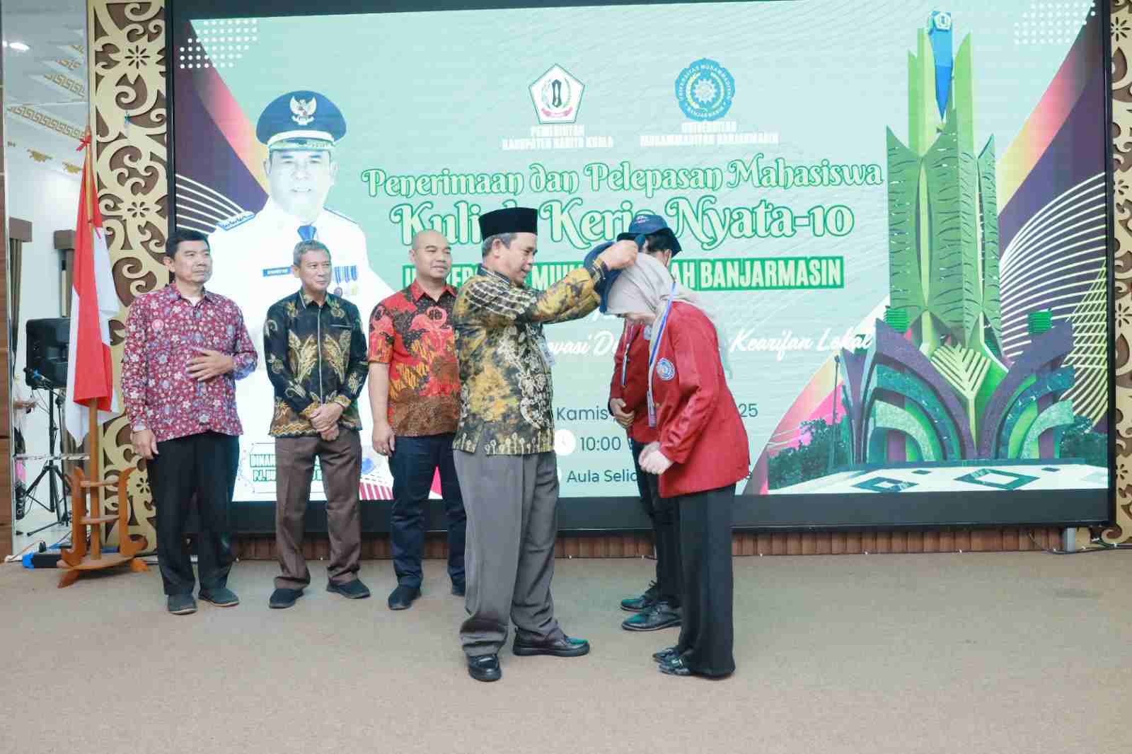 Pj. Bupati Barito Kuala, Dinansyah, S.Sos., M.M., secara simbolis menyematkan tanda peserta kepada mahasiswa KKN Universitas Muhammadiyah Banjarmasin (UMB) ke-10 tahun 2025 di Aula Selidah Marabahan.